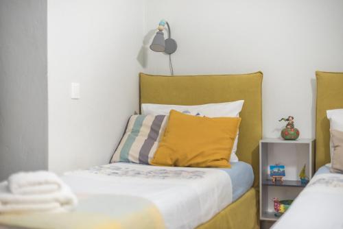 a bedroom with a bed with yellow pillows at Athenian Niche in Plaka Villa by Athenian Homes in Athens