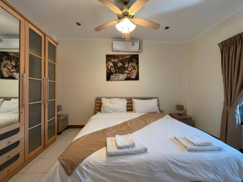 - une chambre avec un lit et un ventilateur de plafond dans l'établissement Resort 2-3BR Huge Pool, BBQ, 300m-Beach, 5 mins to Walking Street, à Pattaya (sud)