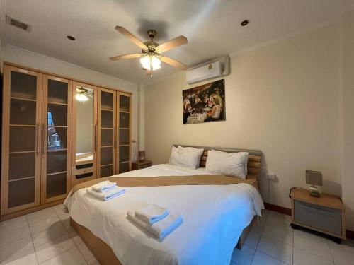 a bedroom with two beds and a ceiling fan at Resort 2-3BR Huge Pool, BBQ, 300m-Beach, 8 mins to Walking Street in Pattaya South