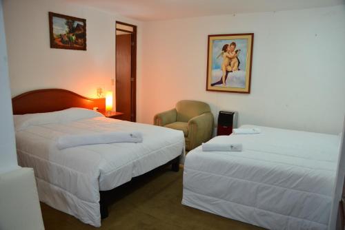 a hotel room with two beds and a chair at Qallwa Asia in Asia