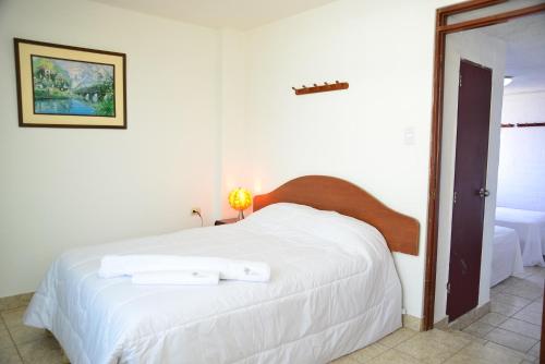 a bedroom with a white bed with two towels on it at Qallwa Asia in Asia