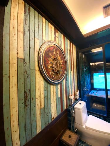 a bathroom with a toilet and a plate on the wall at Bantunglom Resort in Mae Rim
