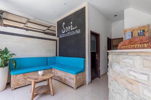 a room with a blue couch and a table at Surf Retreat Villa Sari Bali in Pulukan