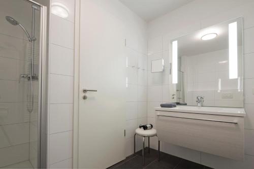 Un baño blanco con lavabo y ducha. en Exquisit 4, en Norderney