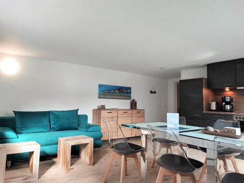 un salon avec un canapé bleu et une table dans l'établissement FeWo Heimathafen, à Bodman-Ludwigshafen