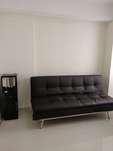 a black leather couch sitting in a room at Palam Mansion at Meisterstadt Pollux Habibie Apartment in Batam Center