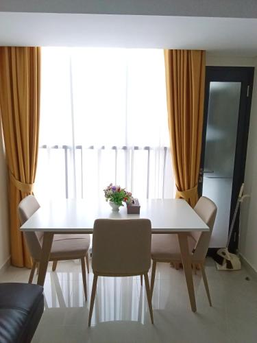 a dining room table with chairs and a white table at Palam Mansion at Meisterstadt Pollux Habibie Apartment in Batam Center