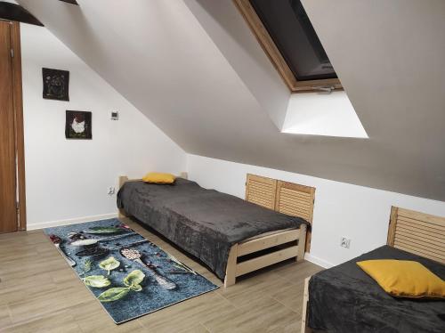 1 dormitorio con 2 camas y alfombra en Ranczo Tomaszówka, Lokalik nad Gąską, 