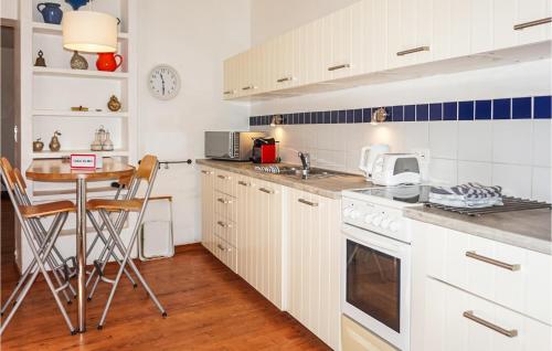 a kitchen with white cabinets and a table with chairs at Lovely Home In Siran With Wifi in Siran