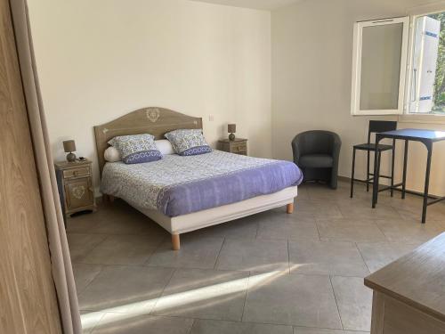 a bedroom with a bed and a table and a chair at Ernella in Aléria
