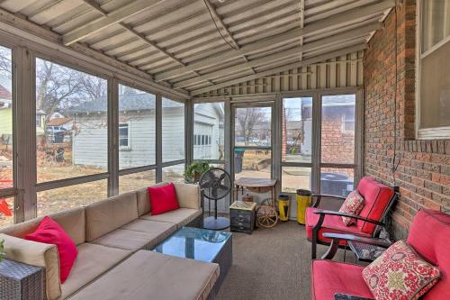 a living room with a couch and chairs and a brick wall at Omaha Vacation Rental about 4 Mi to Downtown in Omaha