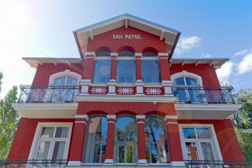 ein rotes Gebäude mit einem Schild darauf in der Unterkunft Villa San Remo in Heringsdorf