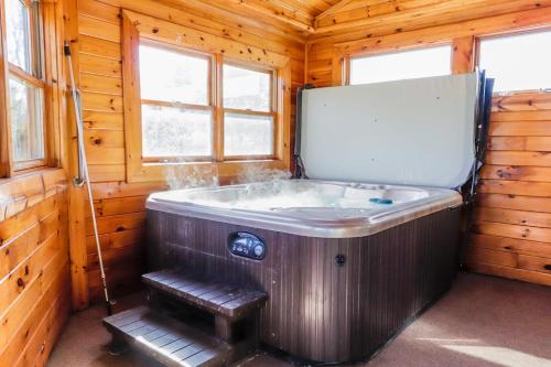 baño con bañera en una cabaña de madera en Hibernation Haven, en McHenry