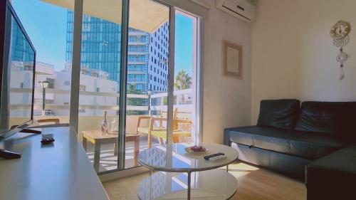 een woonkamer met een bank en een groot raam bij STAY Vivid City Apartment in Limassol