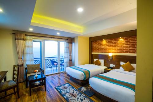 a hotel room with two beds and a balcony at Himalaya Drishya Resort in Dhulikhel