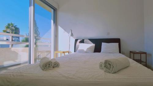 een slaapkamer met een groot bed en handdoeken bij STAY Vivid City Apartment in Limassol