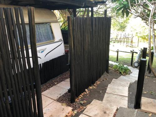 a fence next to a van behind a fence at Fairhills Self Catering Caravan Units in Margate