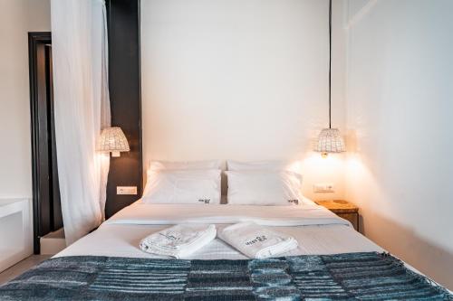 a bedroom with a bed with two towels on it at IfestAu.4 Suites in Fira