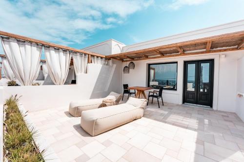 a patio with two couches and a table at IfestAu.4 Suites in Fira