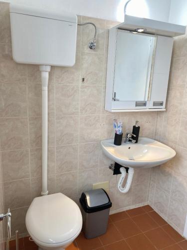 a bathroom with a white toilet and a sink at Panorama Royal Vračar in Vračar (historical)