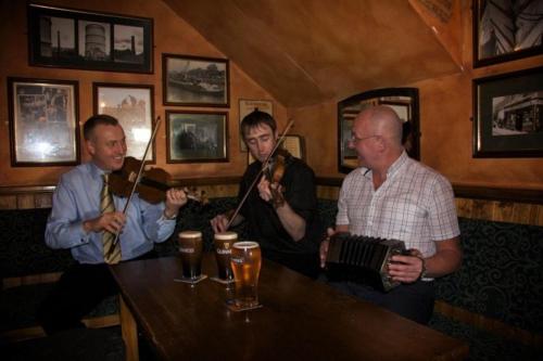 a group of men playing instruments in a bar at The Ferryman Townhouse in Dublin