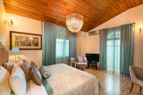 a bedroom with a bed and a living room at Clove Villa in Kandy
