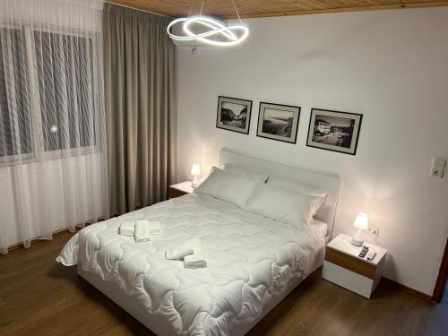 a bedroom with a white bed with two candles on it at E&E Home Sweet Home in Tirana