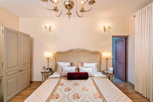 a bedroom with a large bed with a red pillow on it at Clove Villa in Kandy