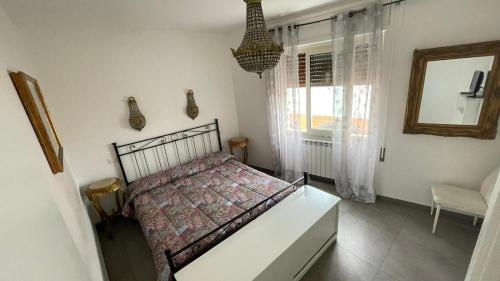 a bedroom with a bed and a window and a mirror at La casa di Mimma in Passoscuro