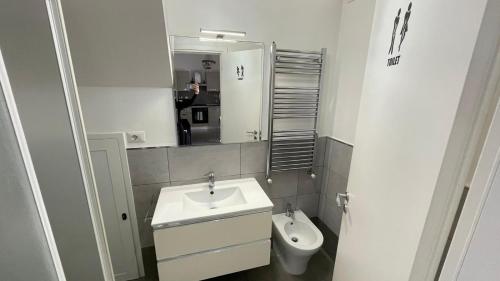 La salle de bains blanche est pourvue d'un lavabo et de toilettes. dans l'établissement La casa di Mimma, à Passoscuro
