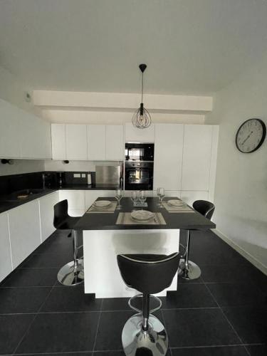 une cuisine avec une table, des chaises et une horloge murale dans l'établissement Charmant T 2 à deux pas du centre-ville et Mer, à Saint-Palais-sur-Mer