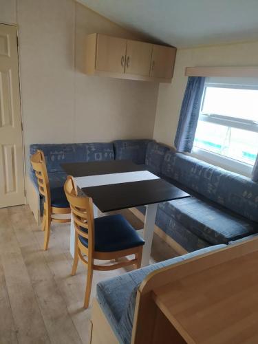 un salon avec un canapé, une table et des chaises dans l'établissement Camping le val du ternois, à Frévent