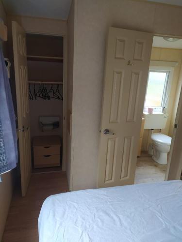 a bedroom with a bed and a bathroom with a toilet at Camping le val du ternois in Frévent