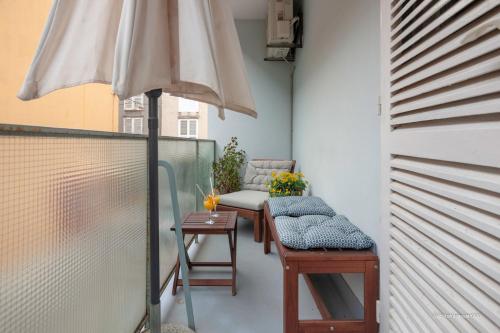 einen Balkon mit einem Sonnenschirm, einem Tisch und Stühlen in der Unterkunft Luciana's city centre hideout in Zadar