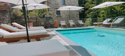 a swimming pool with chairs and umbrellas next to a swimming pool at U Caseddu "studio" in Ortiporio