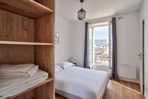 1 dormitorio con cama y ventana grande en Cosy Residence Paris Sud en Ivry-sur-Seine