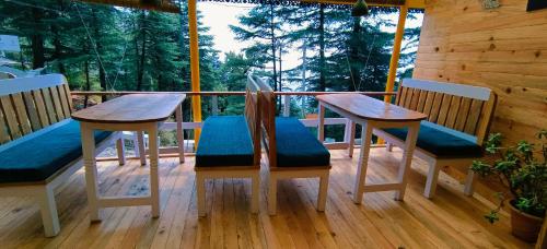 un porche con 2 mesas y sillas en una terraza en Mcleodganj Bed & Breakfast, en McLeod Ganj