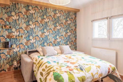 a bedroom with a bed with a floral wallpaper at Du haut des rives - Bel appt pour 4 in Caudebec-en-Caux