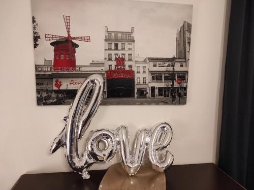 a heart shaped balloon in front of a picture of a windmill at CASA ANNIO Holiday Viterbo in Viterbo