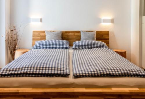 a bed with two blue and white checked pillows at Ferienwohnungen Veronika Wohnung 1 in Mittenwald