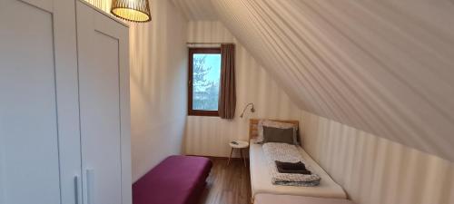 ティハニにあるFüge Vendégház Sajkodのベンチと窓付きの小さな客室です。