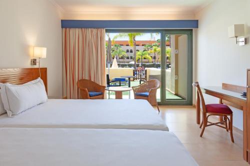 a bedroom with a bed and a desk and a table at Playamarina in Isla Canela