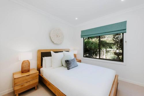 ein Schlafzimmer mit einem weißen Bett und einem Fenster in der Unterkunft Ballantyne at Bombira - An Indulgent Country Escape in Mudgee