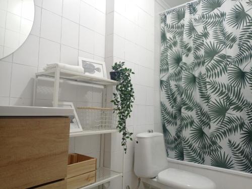 a bathroom with a toilet and a shower curtain at Casa Lamela in Villasante