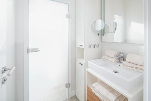 諾德奈的住宿－Nordstrandperle Ap O3，白色的浴室设有水槽和镜子