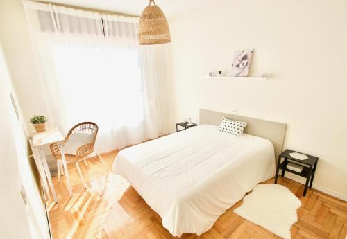 a white bedroom with a bed and a window at Casa Lamela in Villasante