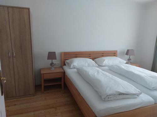 Schlafzimmer mit einem Bett mit weißer Bettwäsche und Kissen in der Unterkunft Ferienwohnung Salzafeld in Bad Mitterndorf