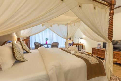 a bedroom with a large white bed with curtains at Bali Hotel in Phnom Penh