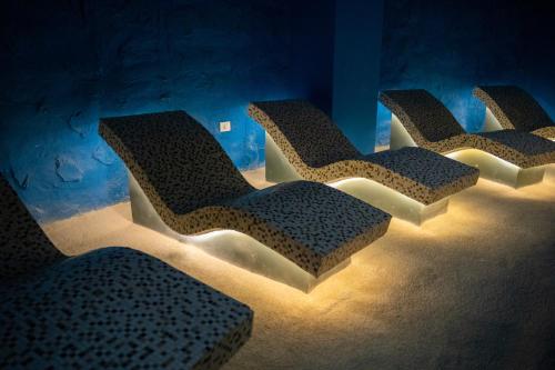 four empty chairs in a room with lights at Bougainville Bay Hotel in Sarandë