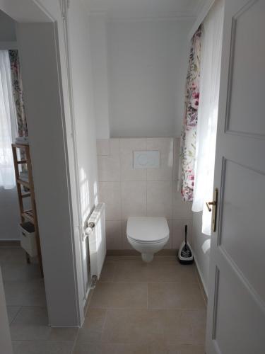 a white bathroom with a toilet and a window at Ferienwohnung Salzafeld in Bad Mitterndorf